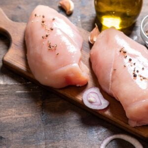 raw chicken breasts with onion and garlic