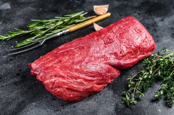 Raw fillet Tenderloin beef meat for steaks with thyme and rosemary. Black background. Top view