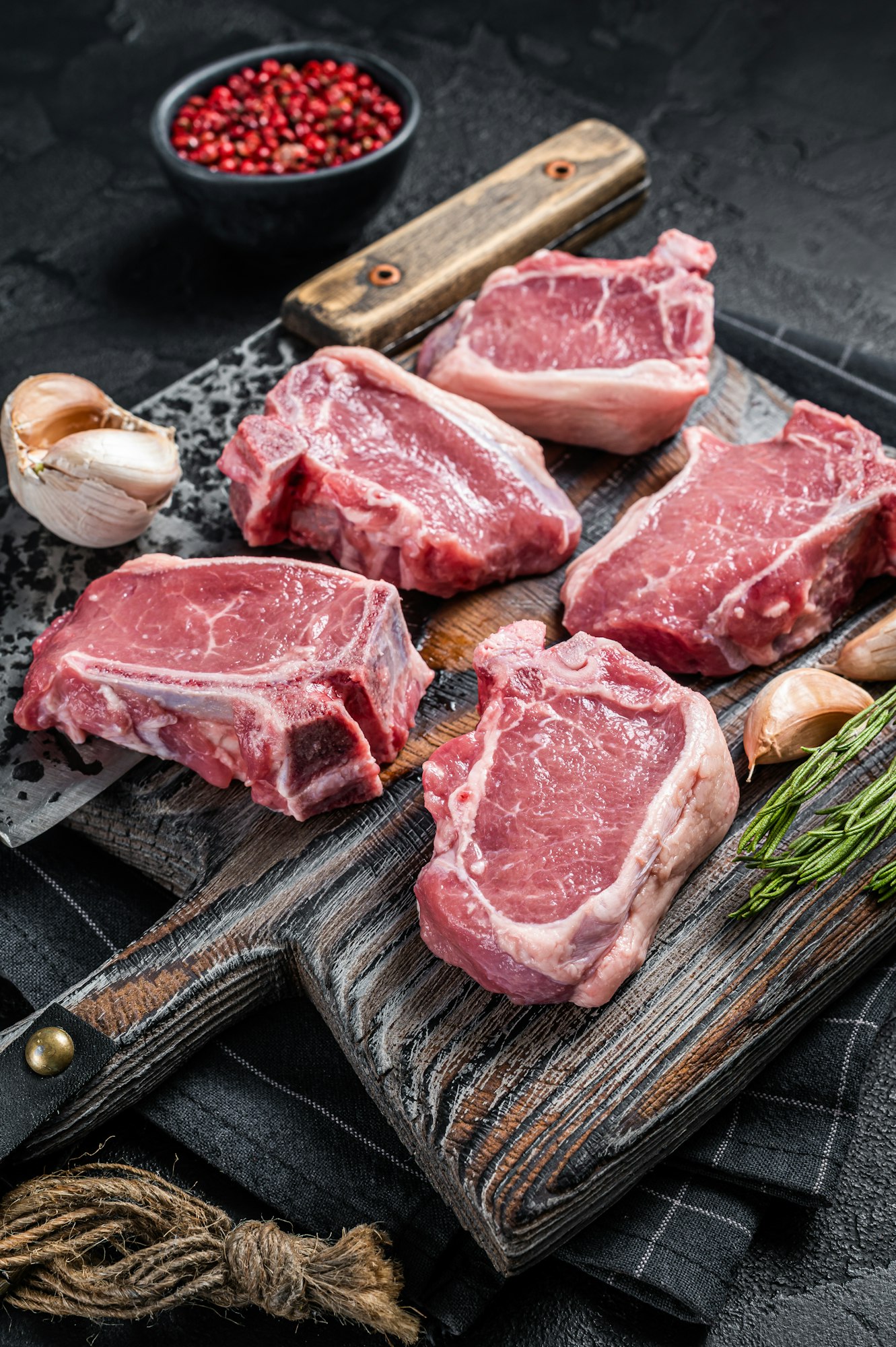 Lamb Loin Chops 1 Fresh Raw lamb loin chops steaks, cutlets on butcher board with meat cleaver.