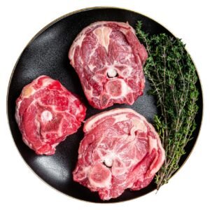 Raw Lamb Gerdan, lamb neck chops on a plate with herbs. Isolated on white background.