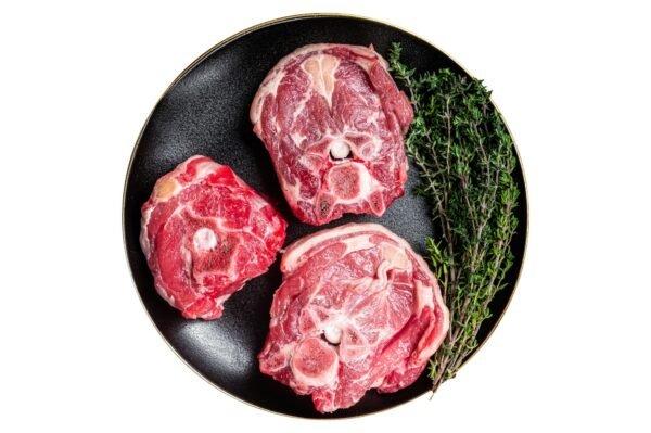 Raw Lamb Gerdan, lamb neck chops on a plate with herbs. Isolated on white background.